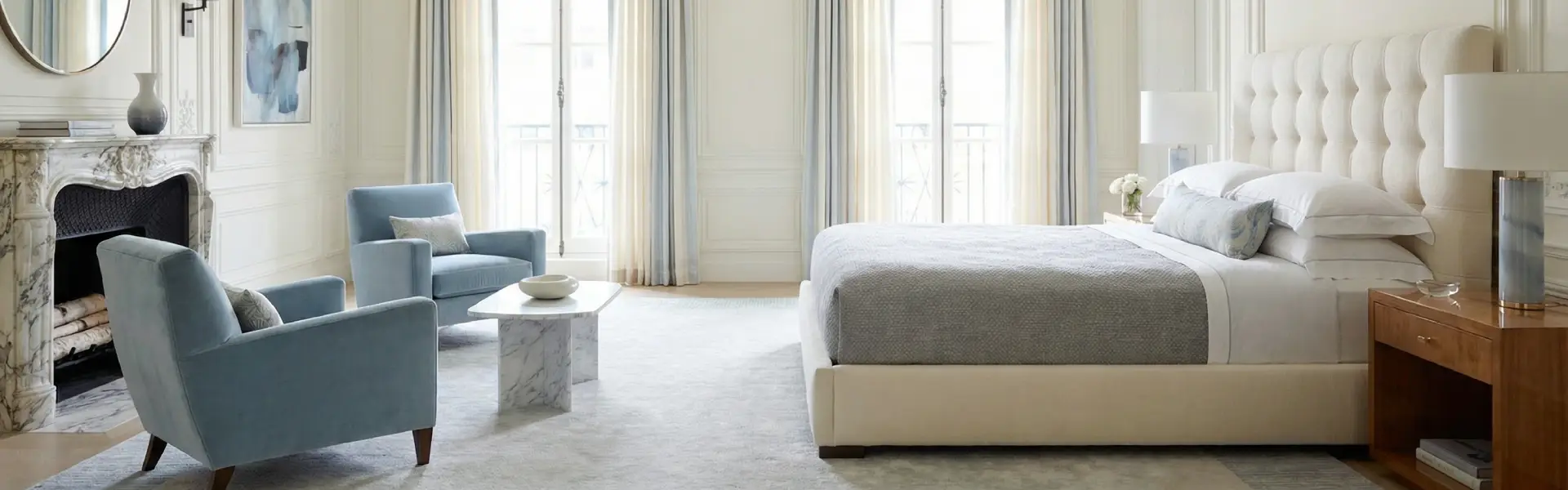 Bedroom decoration ideas: Parisian room with tufted white bed, blue velvet armchairs, marble fireplace, and sheer curtains.