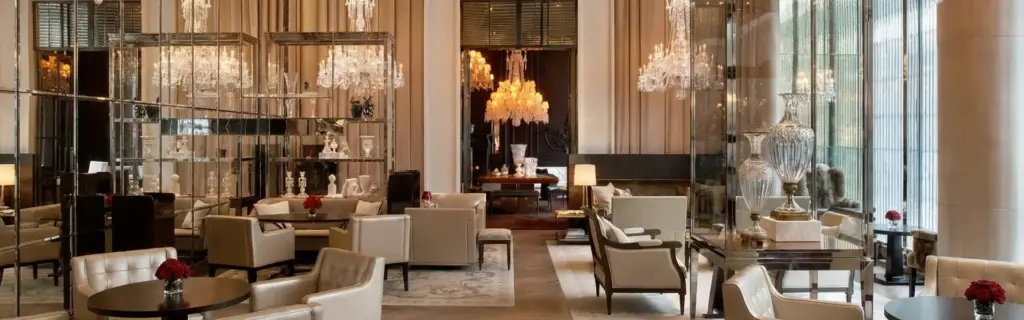 Luxury hotel interior architect: palace lobby with crystal chandeliers, cream armchairs, mirrored shelves, and red roses.
